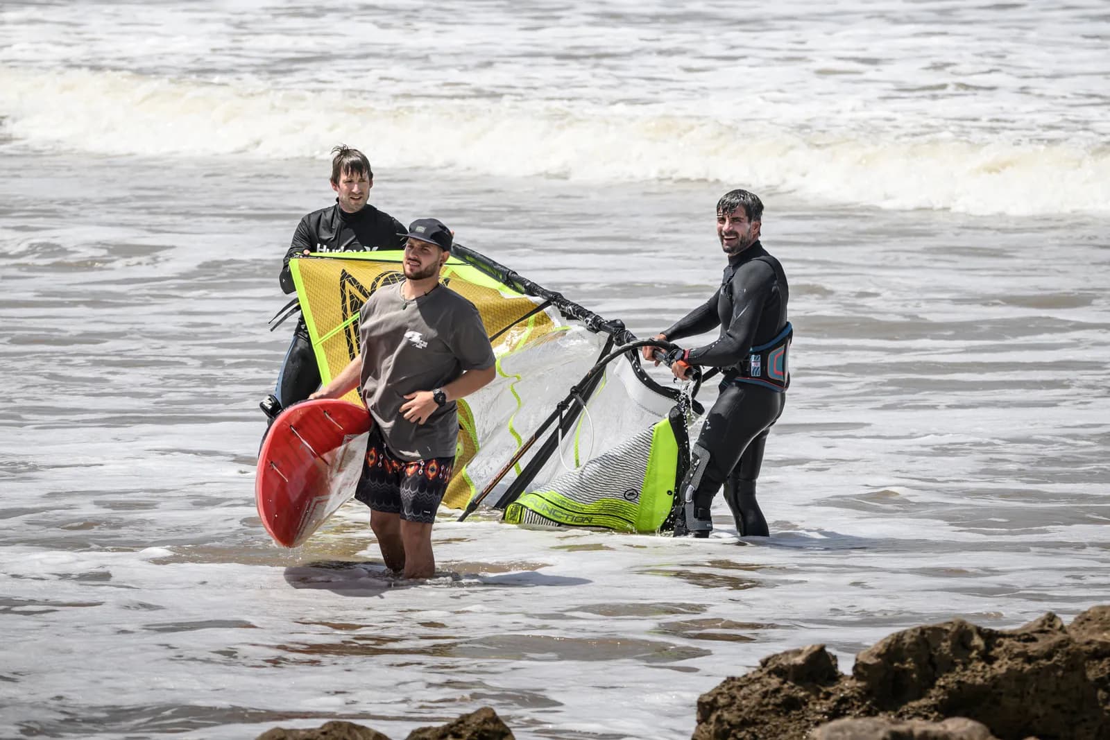 Riders carrying gear out of the water